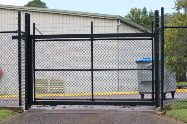 Automatic sliding security gate with barbed wire on top
